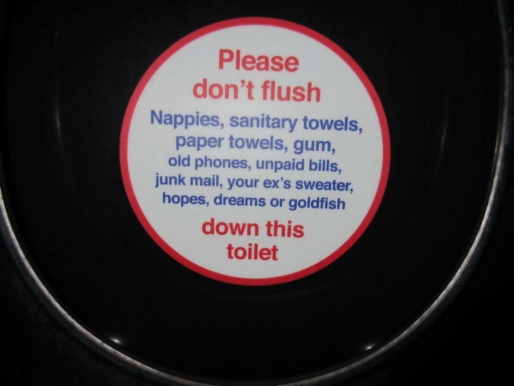 A sign reading Please don't flush down this toilet