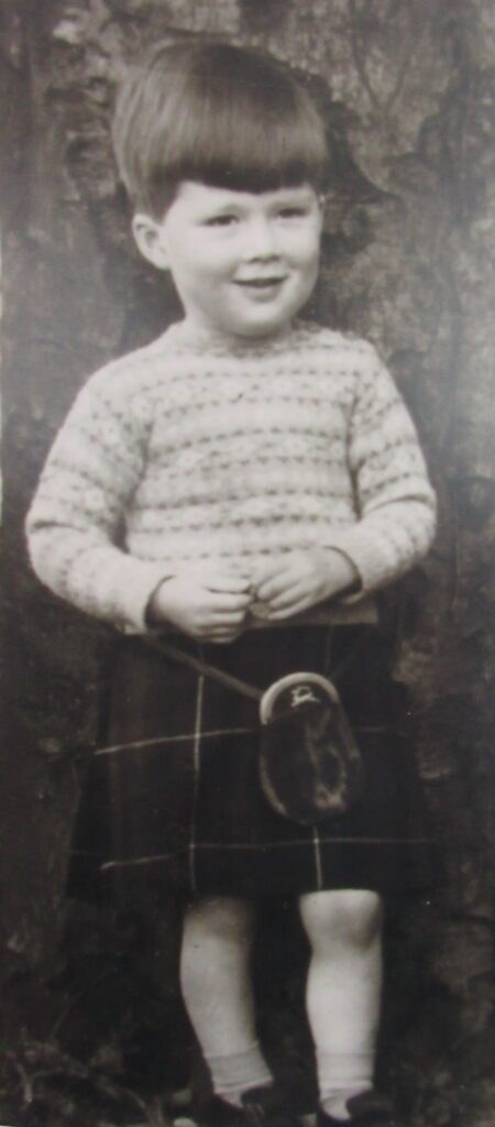 Mike as a small boy in a kilt and jumper